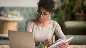 Young black lady at computer terminal studying